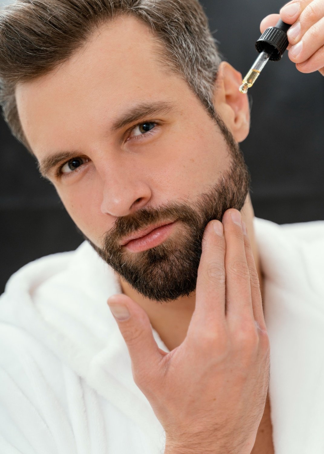 Image avec homme qui met du sérum sur sa barbe